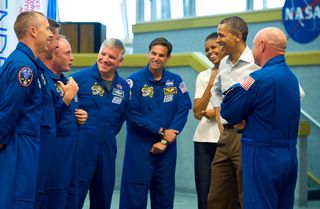President Barack Obama and First Lady Michelle Obama share a laugh with STS-134 space shuttle Endeavor commander Mark Kelly (with back to camera), right, and shuttle astronauts, from left, Andrew Feustel, European Space Agency’s Roberto Vittori, Michael F
