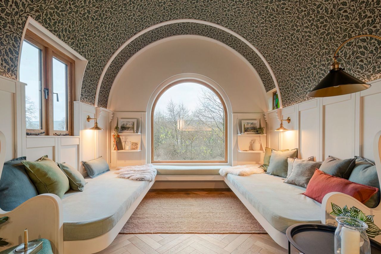 A u shaped cream sofa inside the living area of the caravan