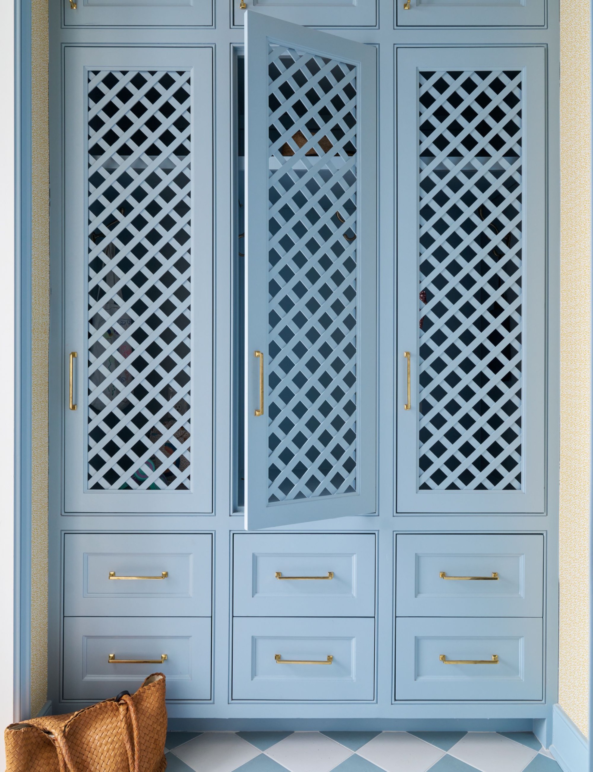 Laundry room with blue fretwork cabinetry by Katie Davis Design