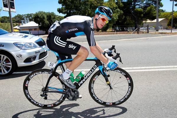 Michael Rogers makes his way through the convoy back to the peloton.