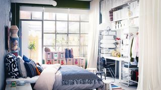 a garage converted into a white and blue bedroom with plenty of Ikea furniture, and floor-to-ceiling windows