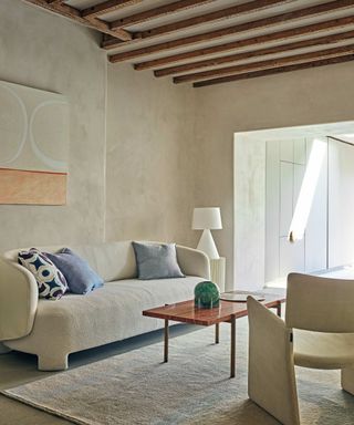 Neutral room with textures walls and cream curved couch