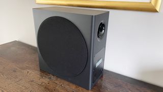 The Samsung HW-Q950A subwoofer on its own on a wooden surface