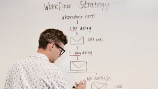 man writing out email marketing steps on whiteboard
