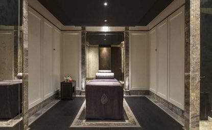 The Lanesborough Club and Spa London treatment rooms with dark purple beds and marble walls