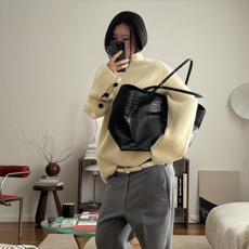 woman in yellow sweater with black tote bag