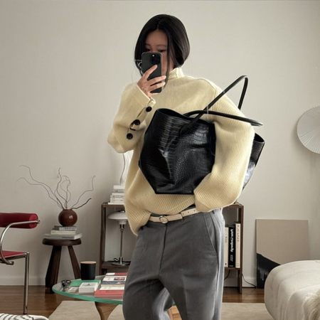 woman in yellow sweater with black tote bag