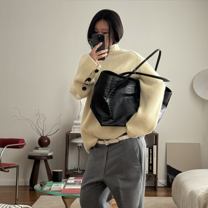 woman in yellow sweater with black tote bag
