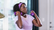 Woman doing dumbbell curls at home