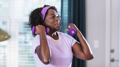 Woman doing dumbbell curls at home