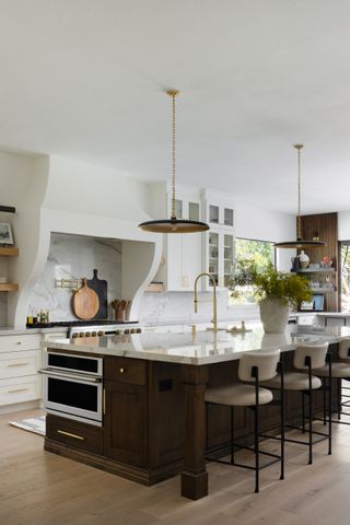 a wood kitchen island with an appliance on the end in a white kitchen