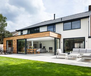 extended house with a timber-clad extension featuring corner sliding doors that completely open up the new space to the patio and garden 