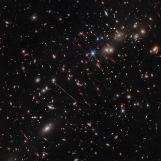 Dozens of stars and galaxies glisten across deep space in this James Webb Space Telescope image of the El Gordo galaxy cluster