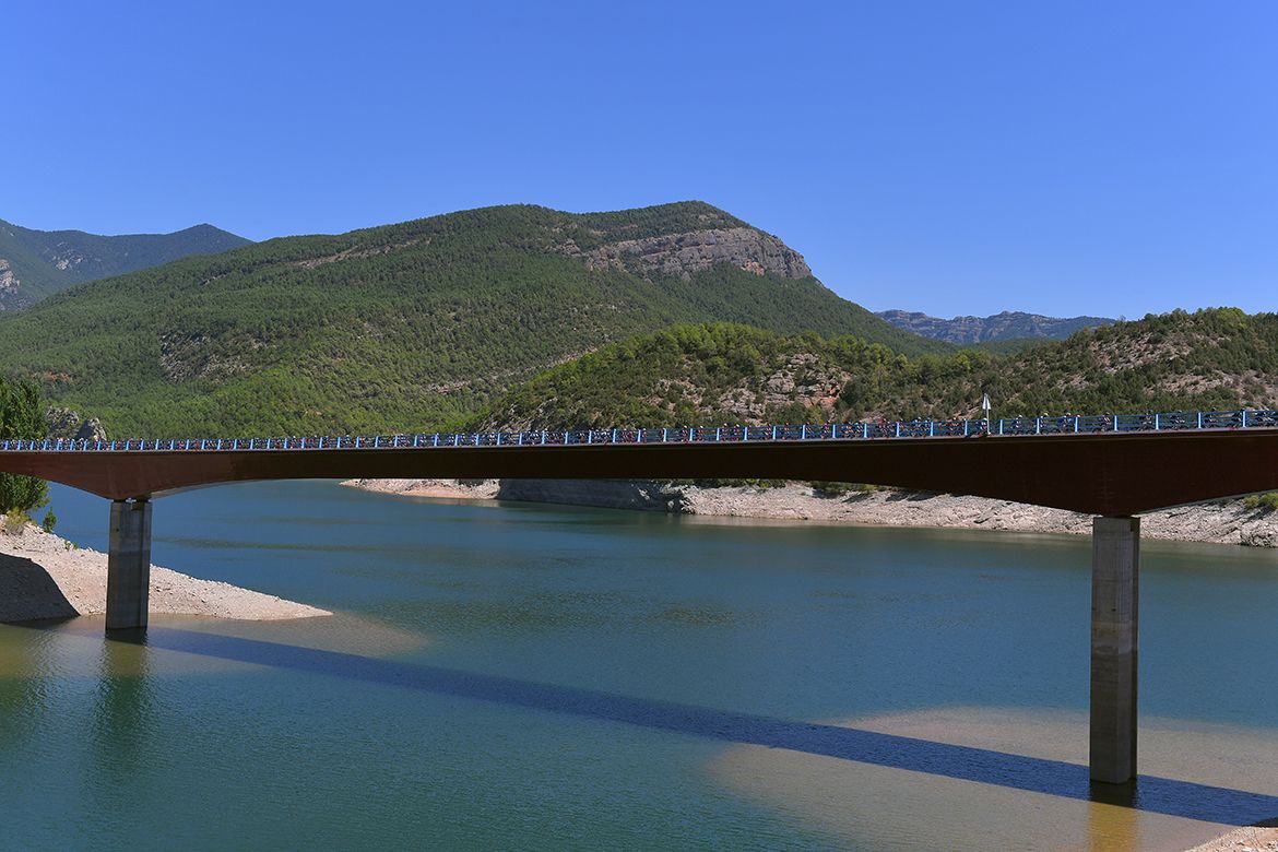 The peloton crosses a bridge
