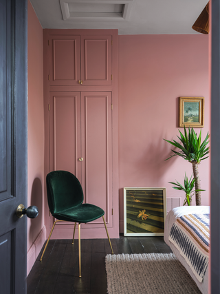 A bedroom with pink walls and a blue door