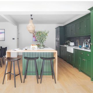 Kitchen-diner with large green island, wood breakfast bar and green units