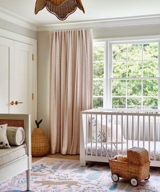 beige nursery with pink curtains and a colorful patterned rug