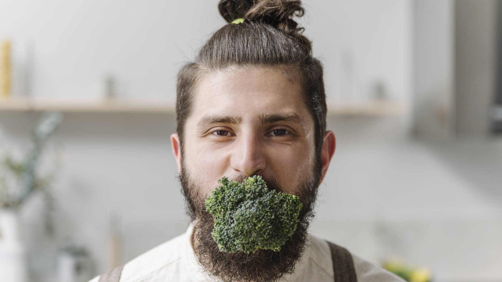 Man has whole head of broccoli in his mouth