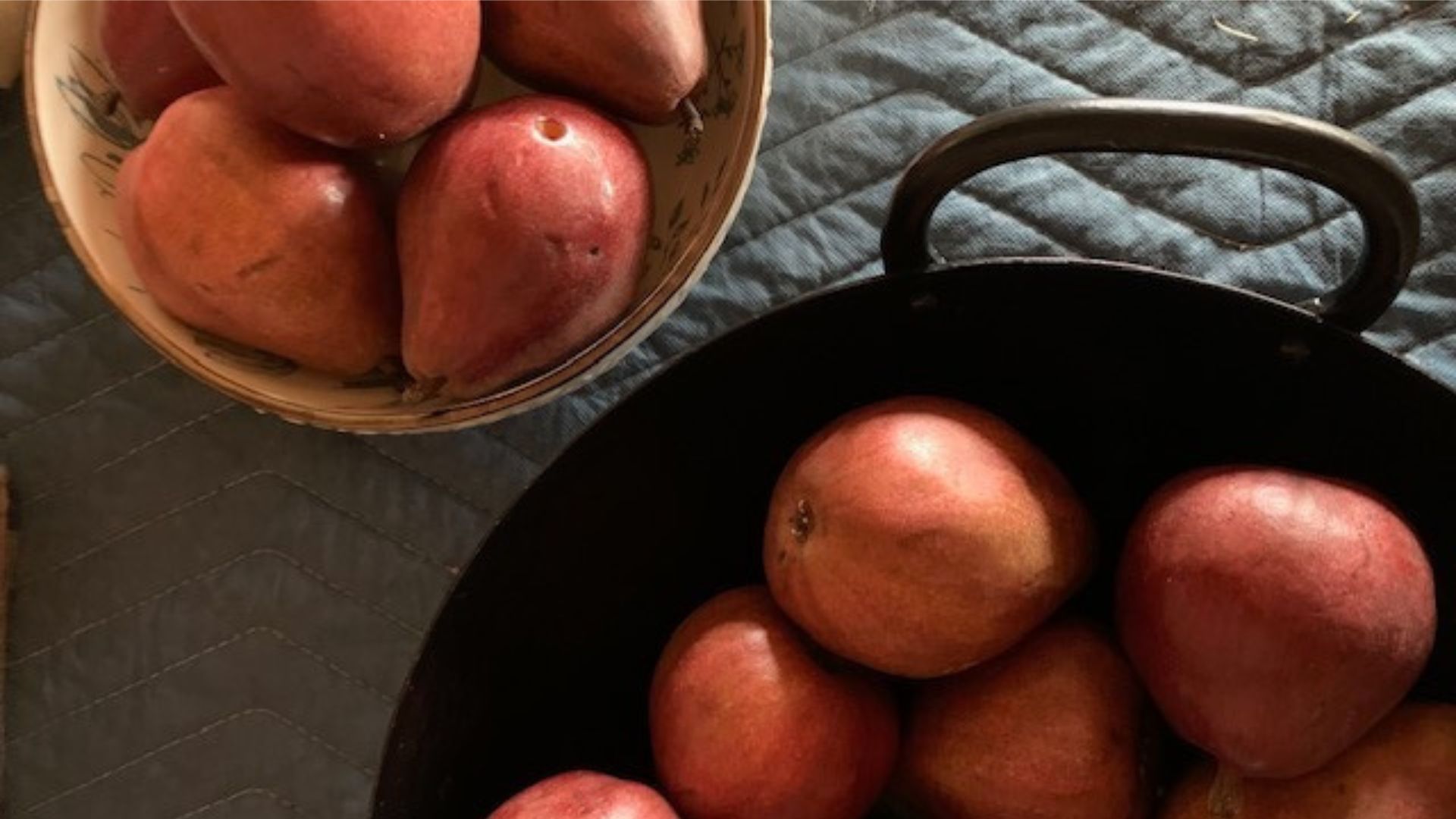Pears in a bowl and a handled cast iron container
