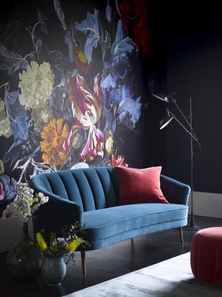 Blue floral mural with dark teal couch and red cushion in velvet