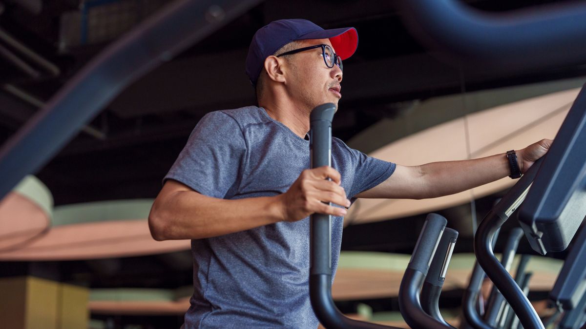 Man using cross-trainer in the gym