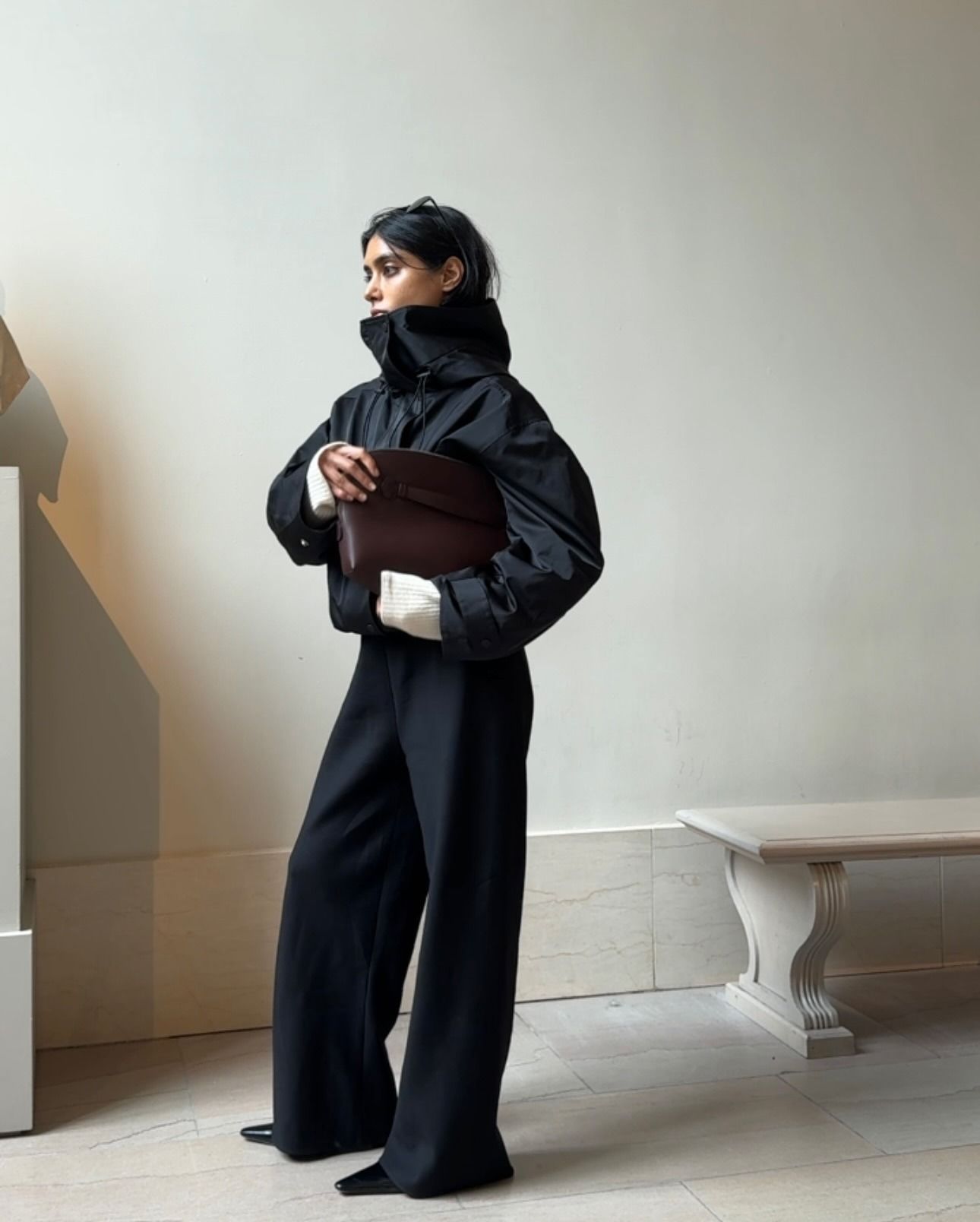 @shayinjune wearing a sporty jacket with black trousers and a clutch.