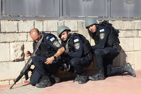 Members of the IDF take cover during a rocket attack