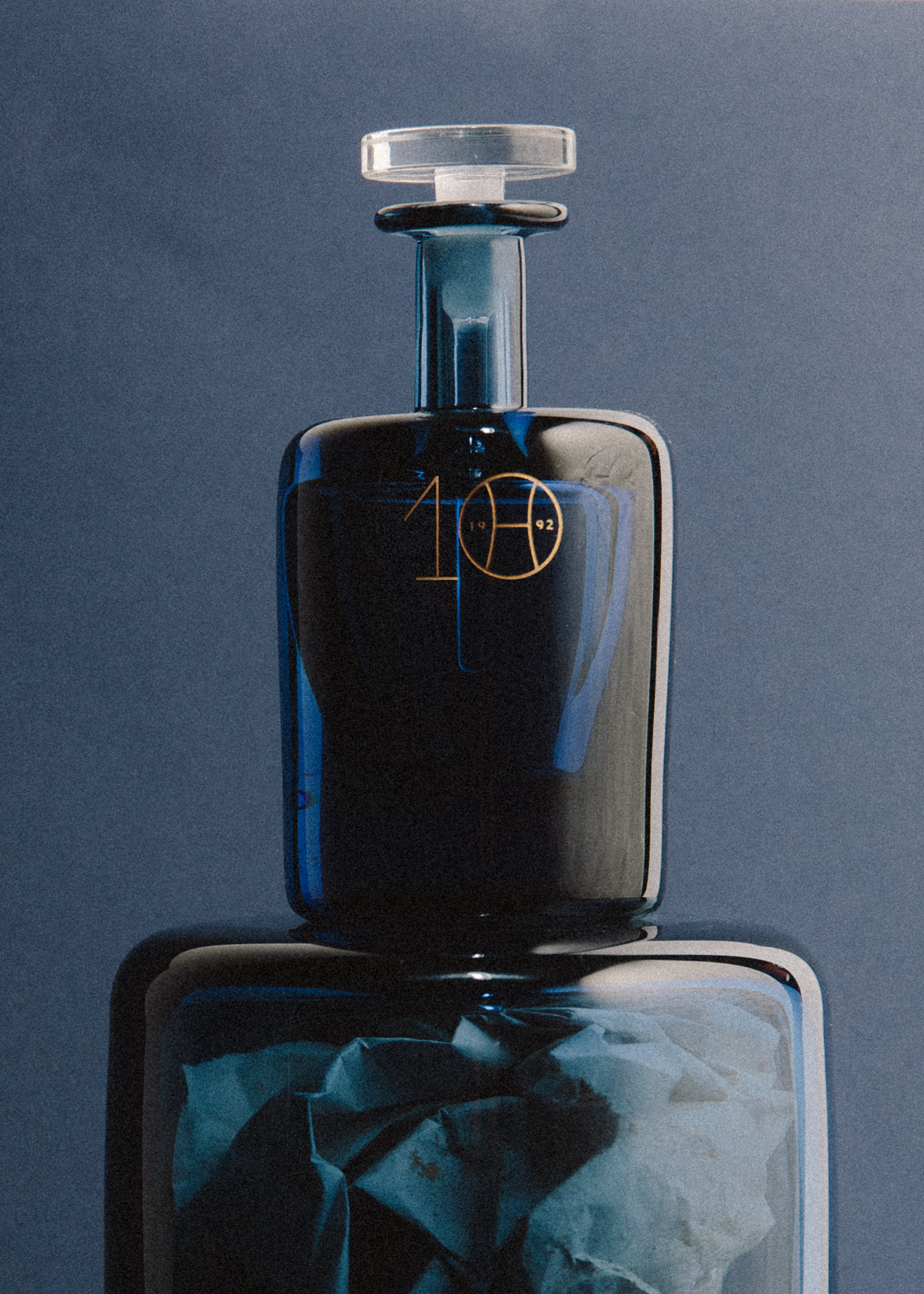 Blue perfume bottle on glass plinth