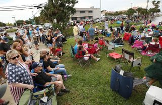 Spectators crowd the lawn at the end of Main Street in Titusville, Fla., to watch SpaceX launch Demo-2, its first astronaut launch for NASA, from the Kennedy Space Center on May 27, 2020.