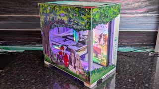 The Starforge Systems Frieren PC, photographed on a dark worktop with the RGB lighting switched on.