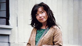 bjork wearing a brown cardigan and grinning in dancer in the dark