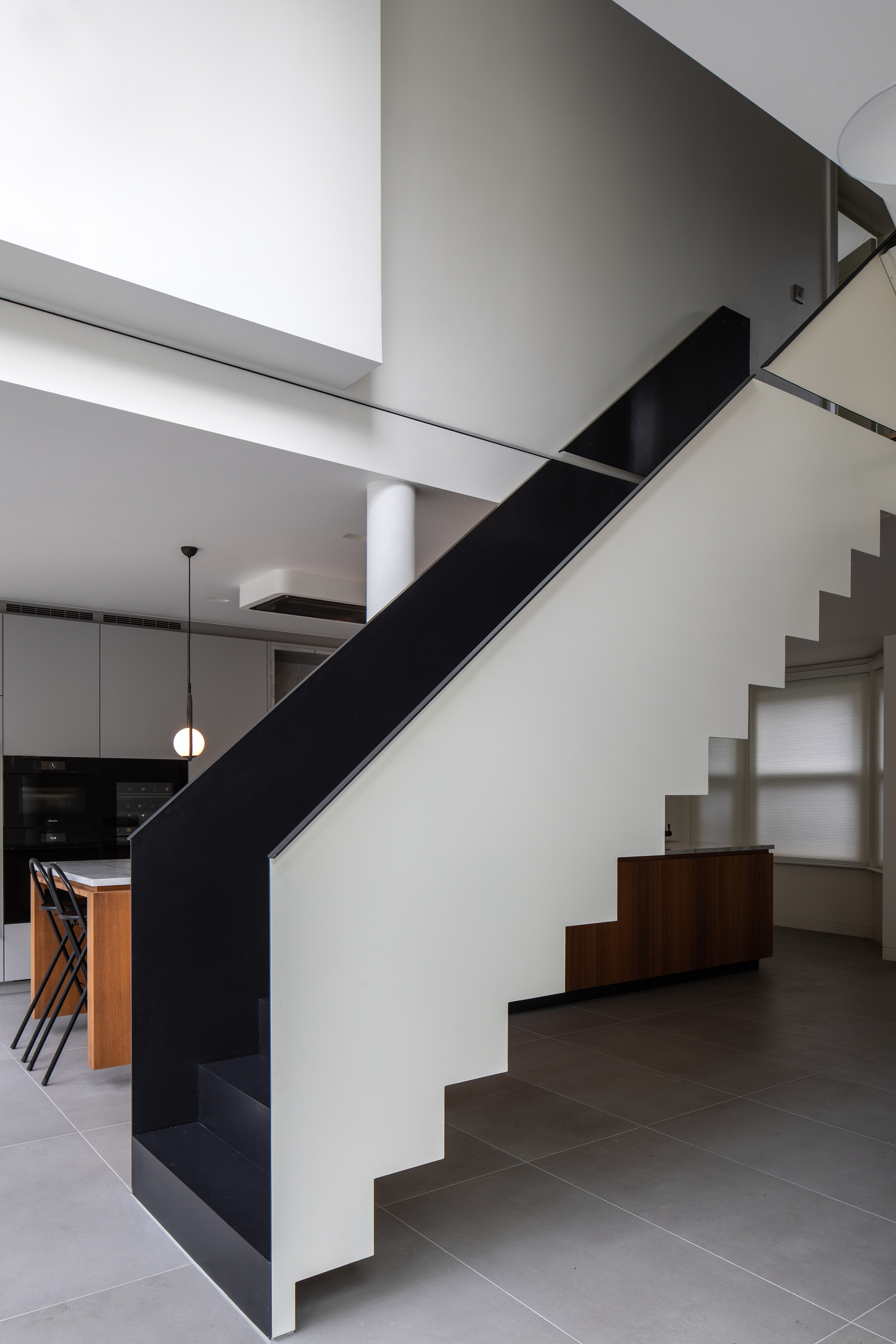 A minimalist monochrome space with a black staircase