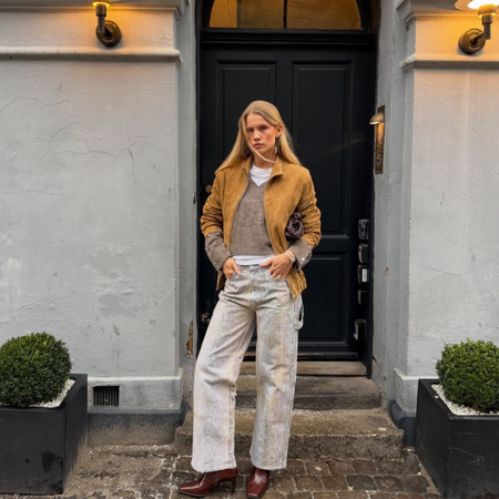 Influencer Andrea Steen wearing a suede jacket, v-neck jumper and snake print jeans.