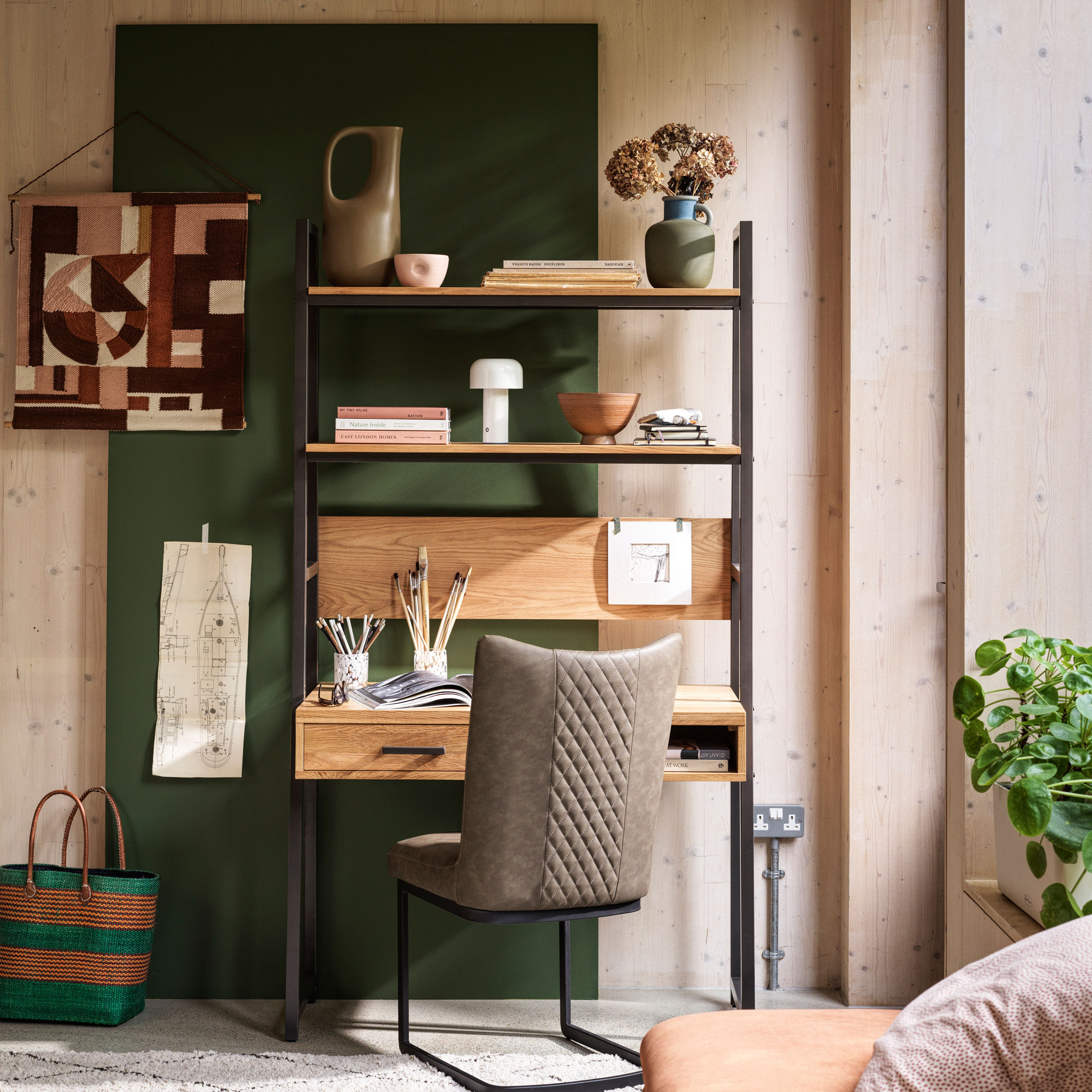 Wooden clad home office with green panel, wood desk and grey desk chair