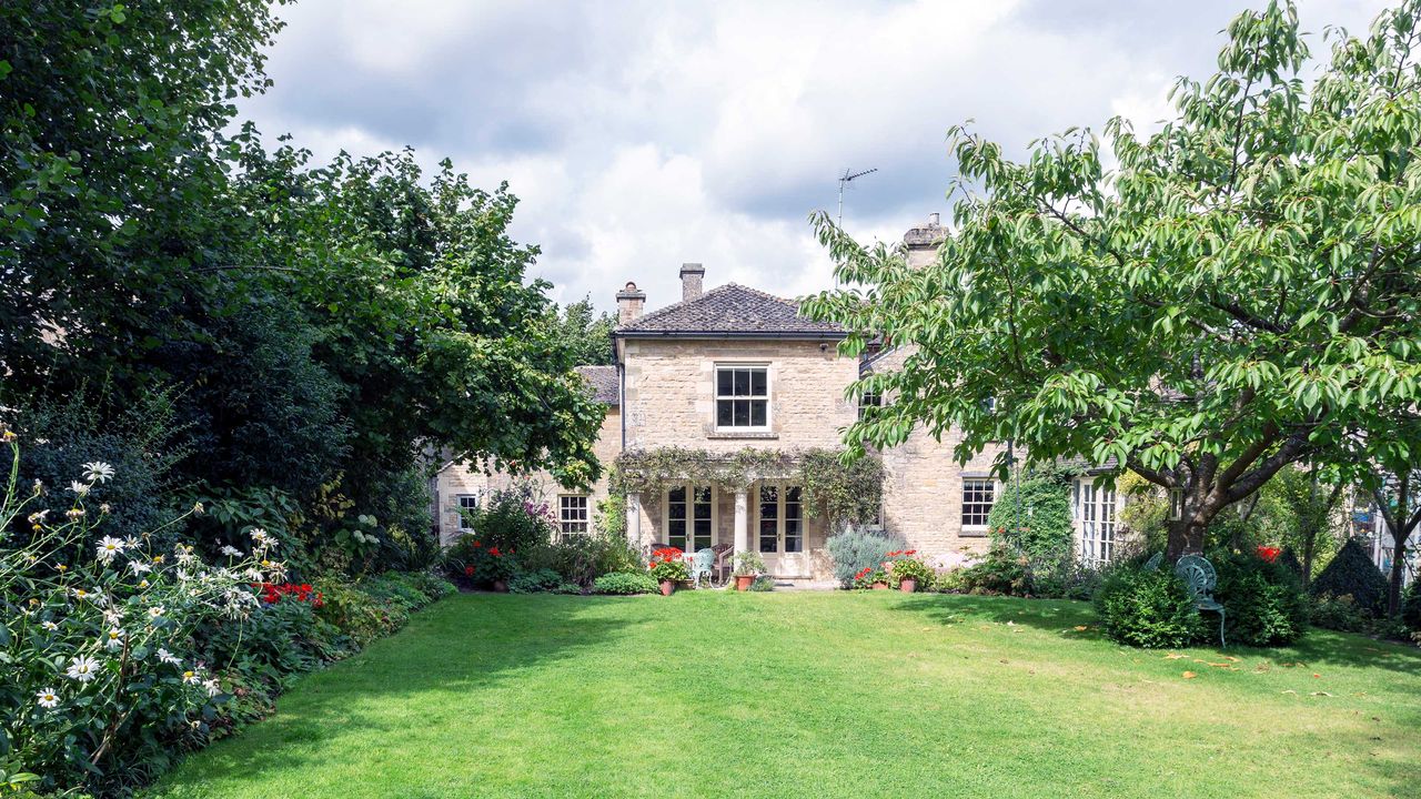 exterior of an old house with well kept lawn and borders