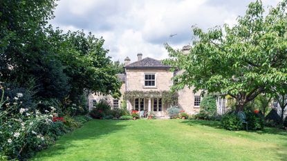 exterior of an old house with well kept lawn and borders