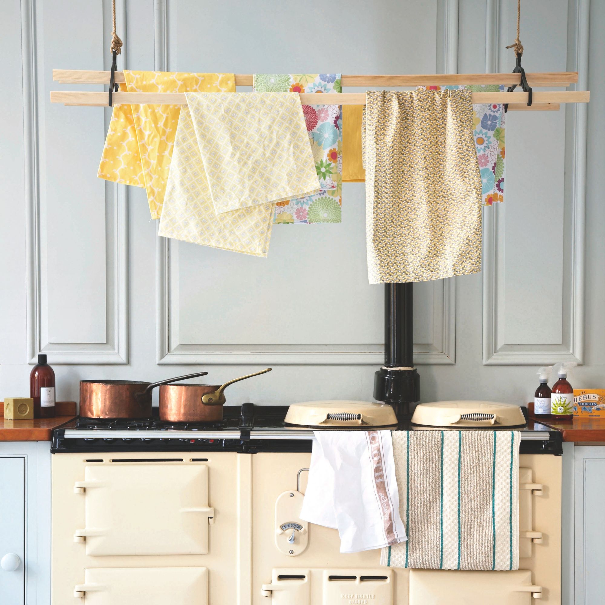 Tea towels hanging on a rack above a cream aga oven