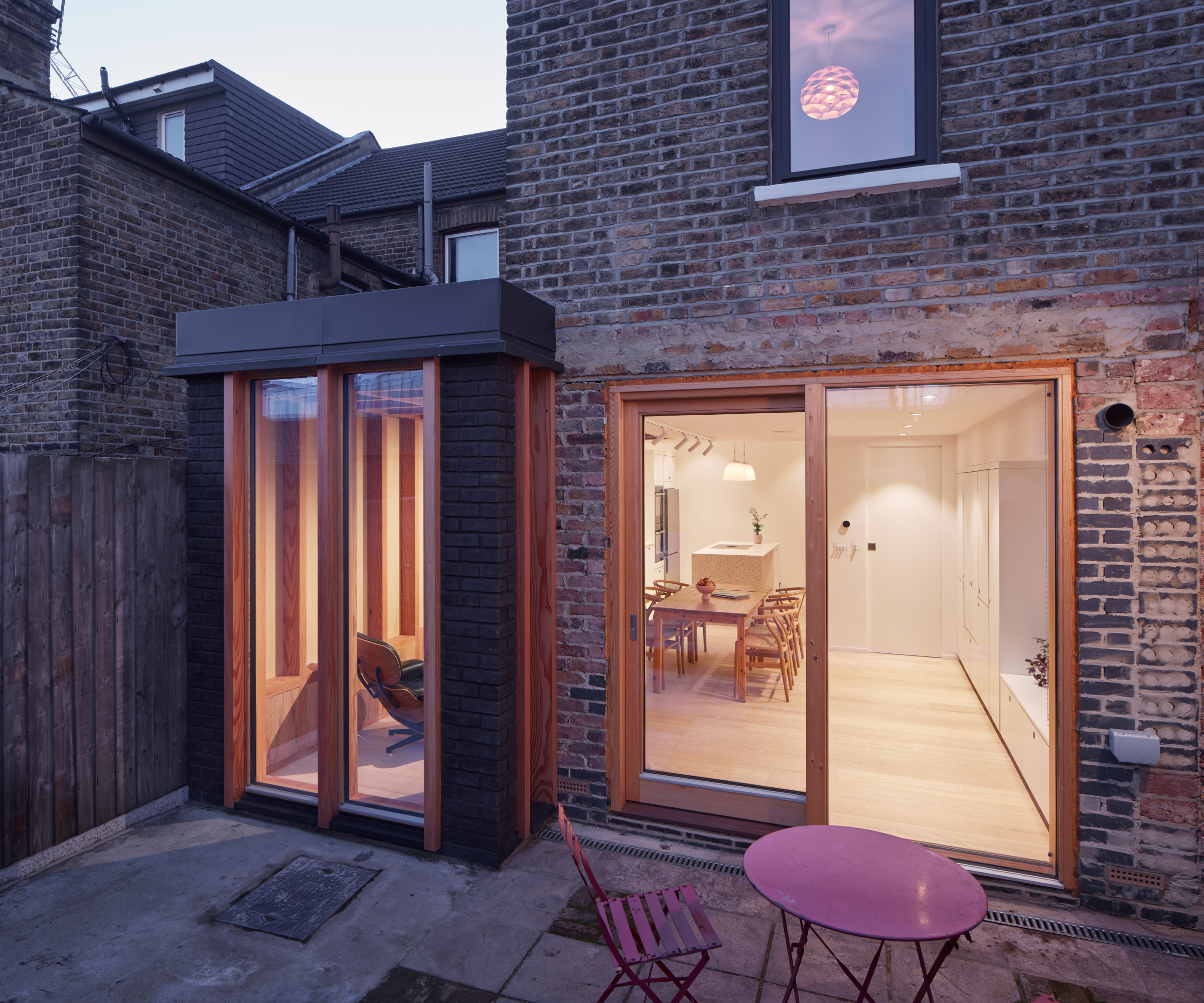small side extension on victorian property with flat roof featuring metal cladding, narrow timber patio doors with large set added to rear of existing property
