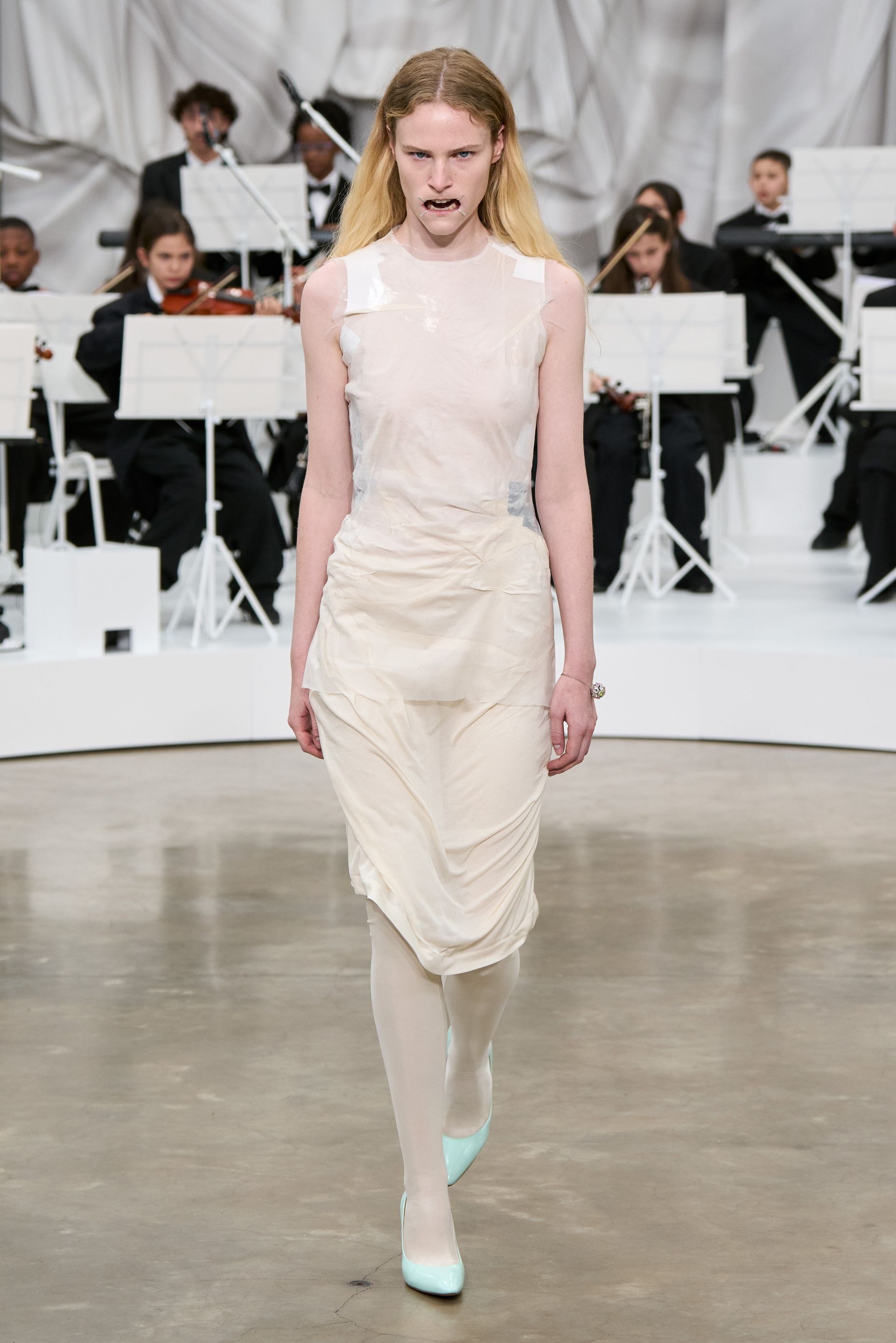 A model at the SS26 Maison Margiela show wearing a four-stitch mouthpiece.