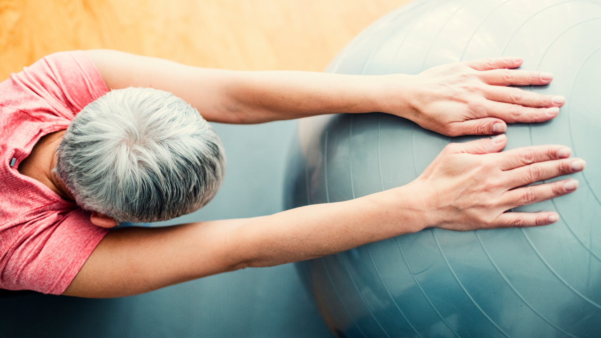 Woman stretching on medicine ball