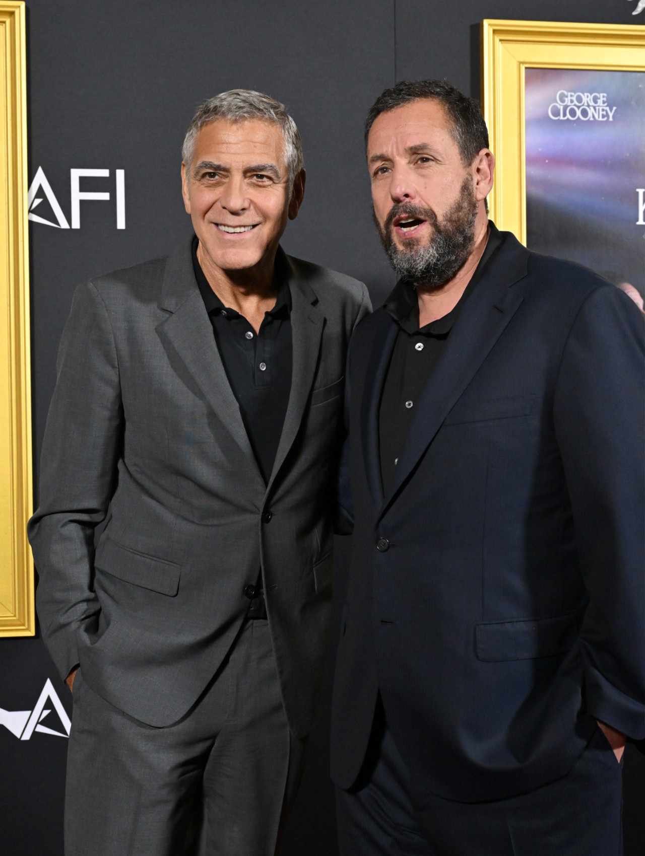 George Clooney and Adam Sandler attend the 2025 AFI FEST - &amp;quot;Jay Kelly&amp;quot; Premiere at TCL Chinese Theater on October 23, 2025 in Hollywood, California. They&#039;re both wearing suits.