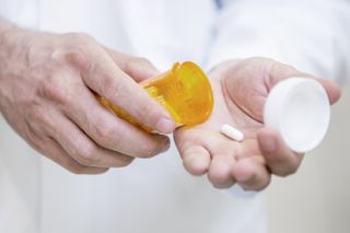 Person putting pill into hand