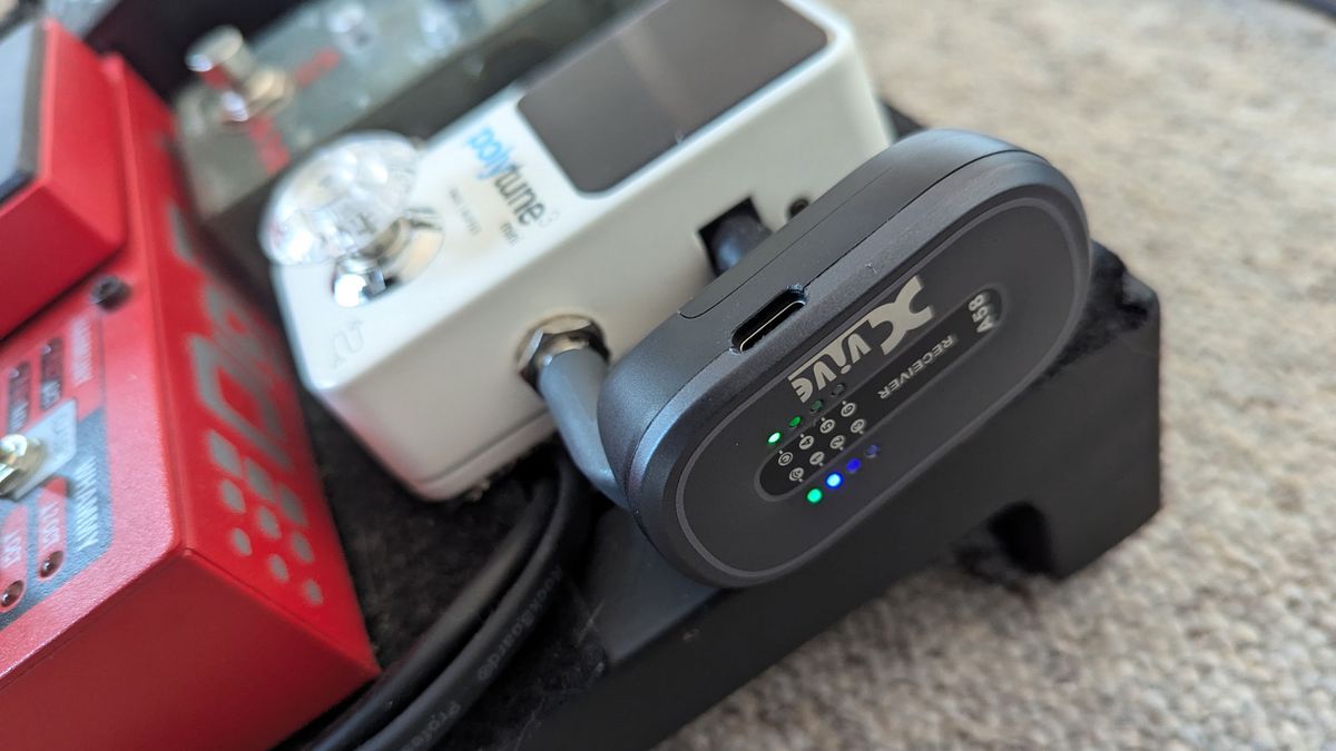 Closeup of Xvive A58 guitar wireless system plugged into TC Electronic PolyTune Mini pedal