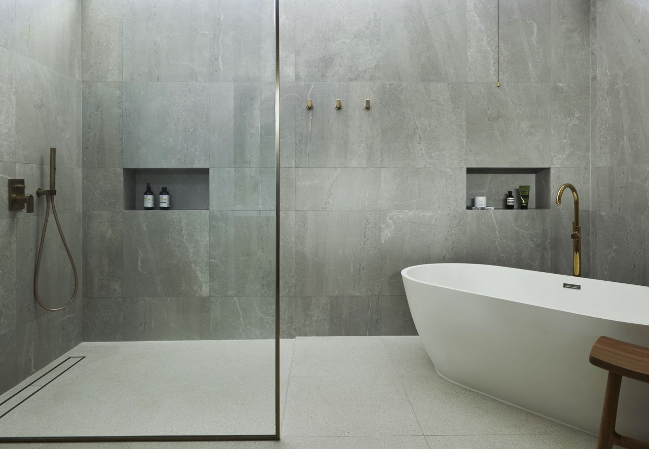 An earthy bathroom with a half shower and half bathtub