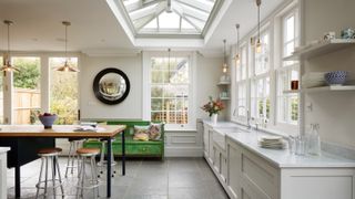 A large white kitchen extension with a lantern roof and a dining table below