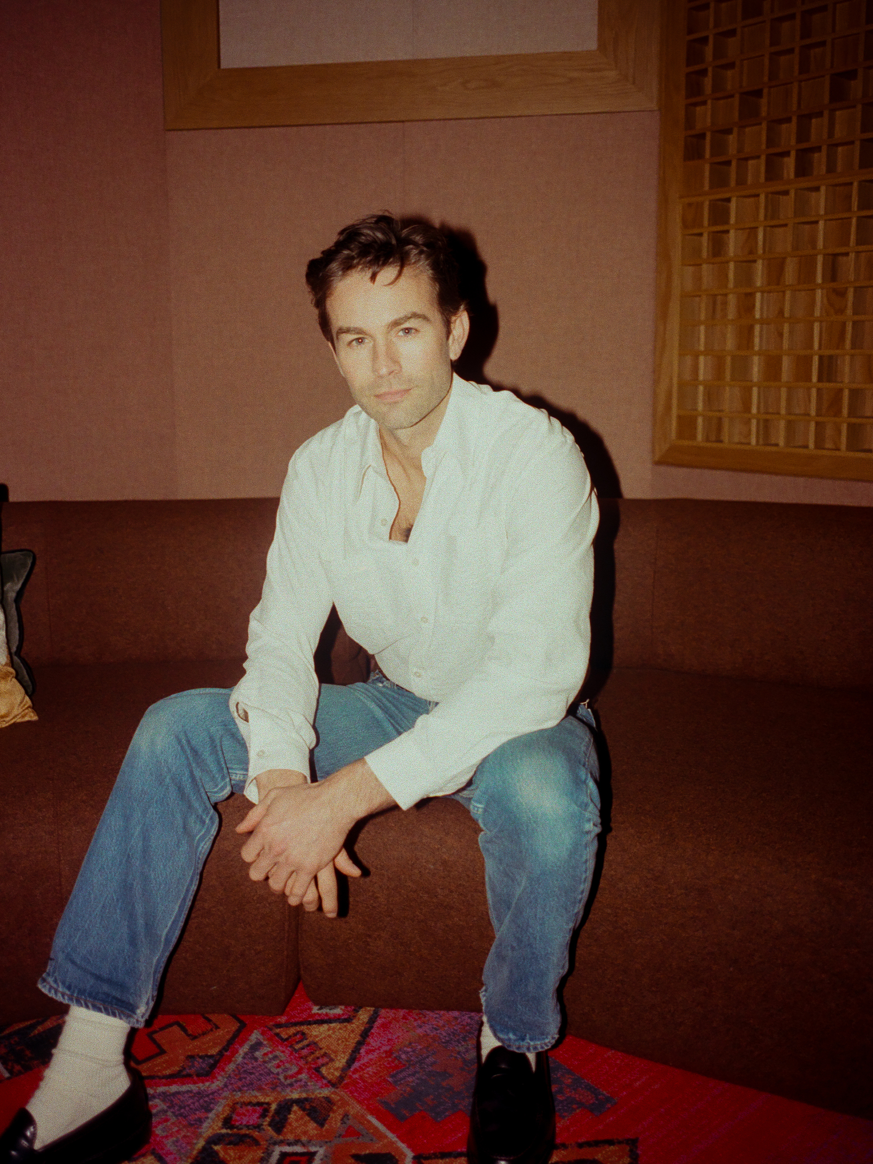 Chace Crawford wearing a plain white button-down shirt and blue jeans.