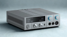 Product shot of the FiiO K15 desktop DAC against a neutral background. The K15 is shown from the front with its display active