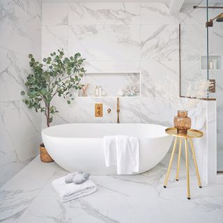 White bathroom with freestanding bath and plant