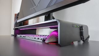 A side view of the Razer Monitor Stand Chroma with a keyboard and mouse stowed underneath it