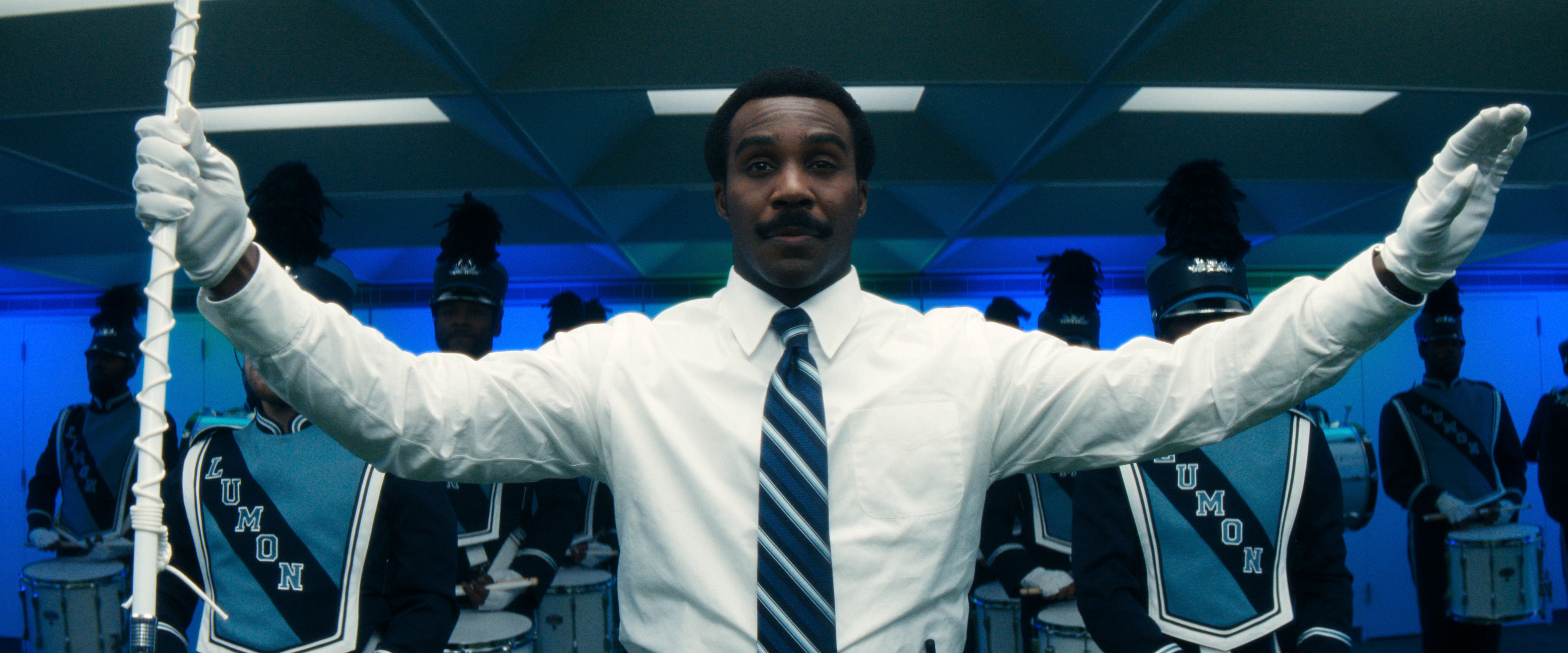 tramell tillman as milchick leading a marching band in severance season 2